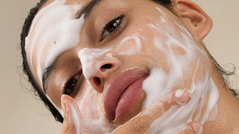 Frau wäscht Gesicht mit Exfoliants