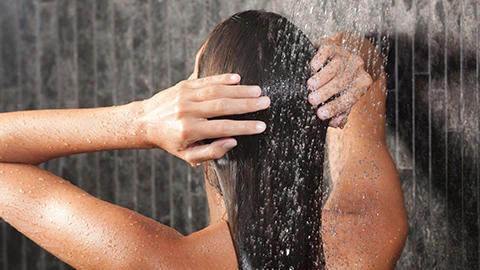 Frau wäscht Haare ohne Shampoo