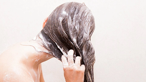 Frau benutzt Shampoo