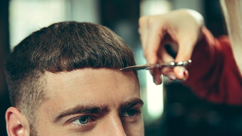 Mann mit Pilzkopf werden Haare geschnitten