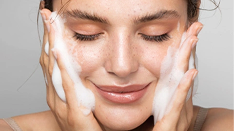 Frau wäscht Gesicht mit Exfoliants