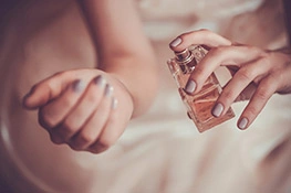 Frau sprüht Parfum auf' title='Must-have für Dates: ein sinnlicher Duft
