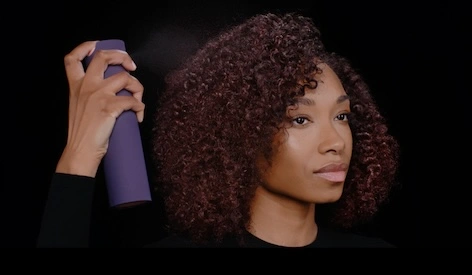 Dyson Define+Refresh Reisegrößen Geschenkset bei flaconi Model sprüht sich Dyson Chitosan Multi-Use Stylingspray in die Haare