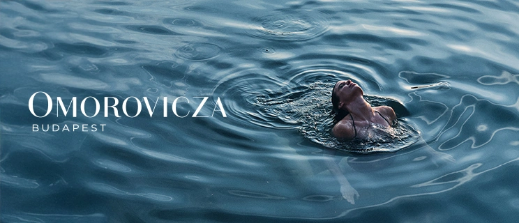 Model schwimmt im Wasser und Markenlogo von Omorovicza